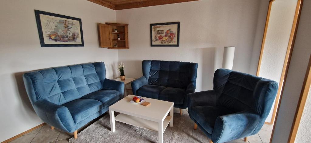 uma sala de estar com duas cadeiras azuis e uma mesa em Ferienwohnung Friedrich em Michelstadt