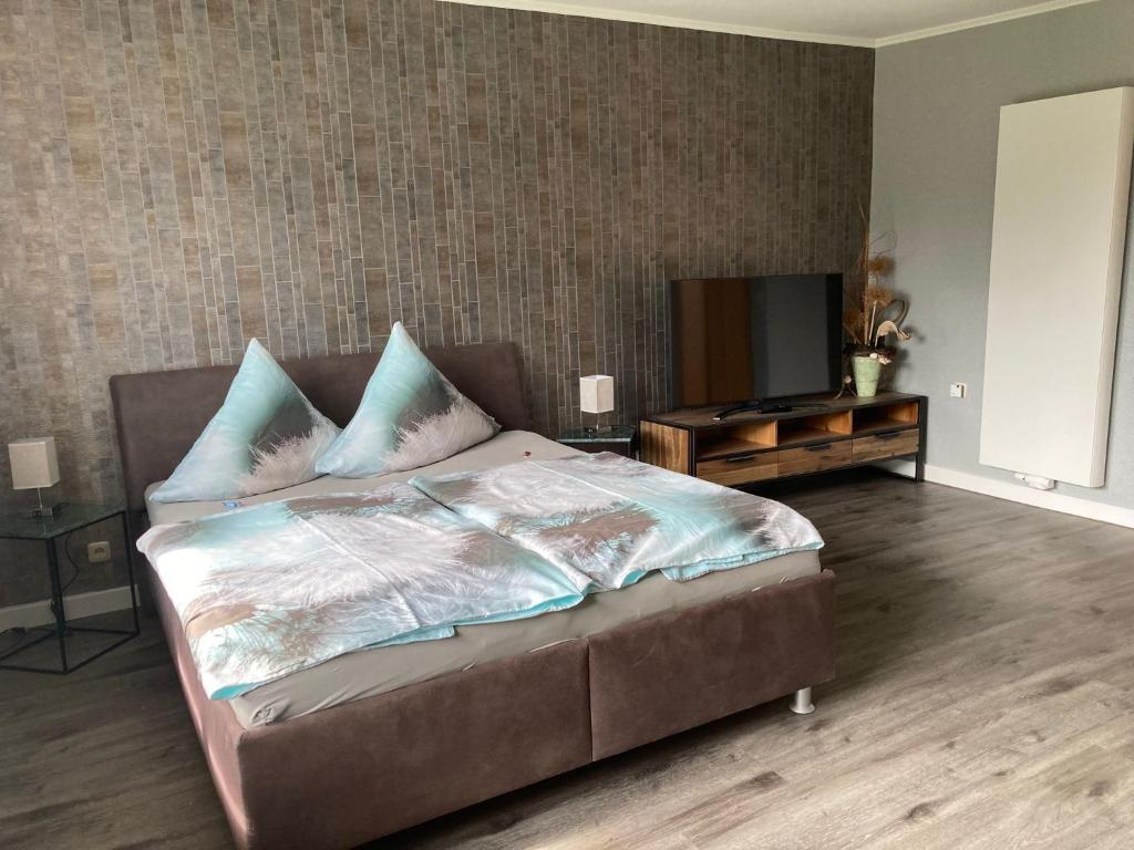 Schlafzimmer mit einem Bett und einem Flachbild-TV in der Unterkunft Ferienwohnung OstseeStrandLäufer 3 in Zingst