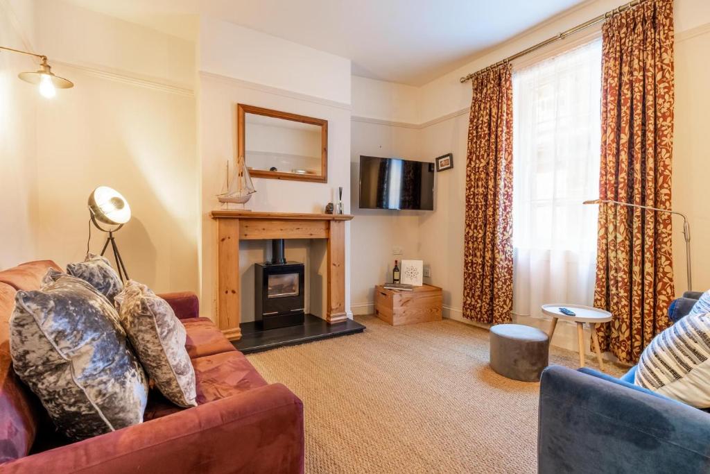 a living room with a couch and a fireplace at Norfolk Historic Townhouse in King's Lynn