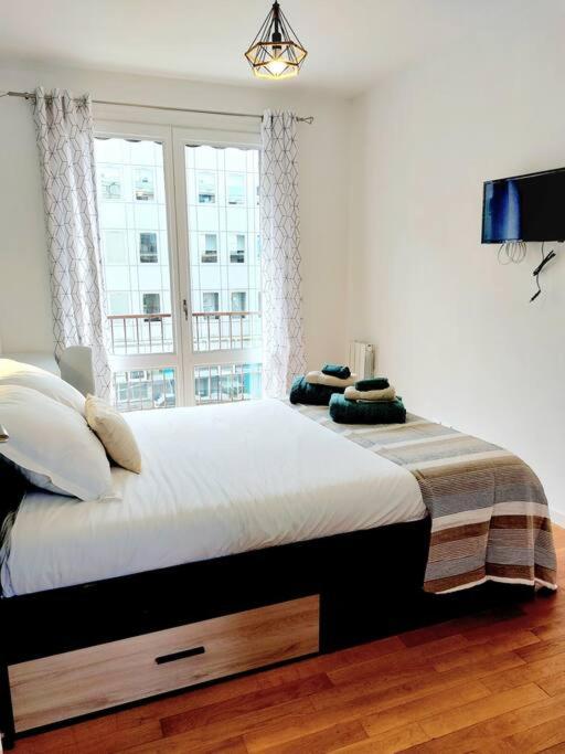a bedroom with a large bed with a window at Lumineux T5 en centre ville in Angoulême