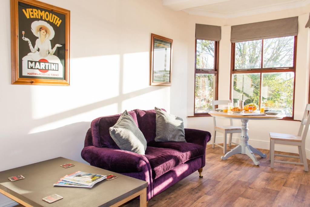 a living room with a purple couch and a table at Rosary Road Apartment in Norwich