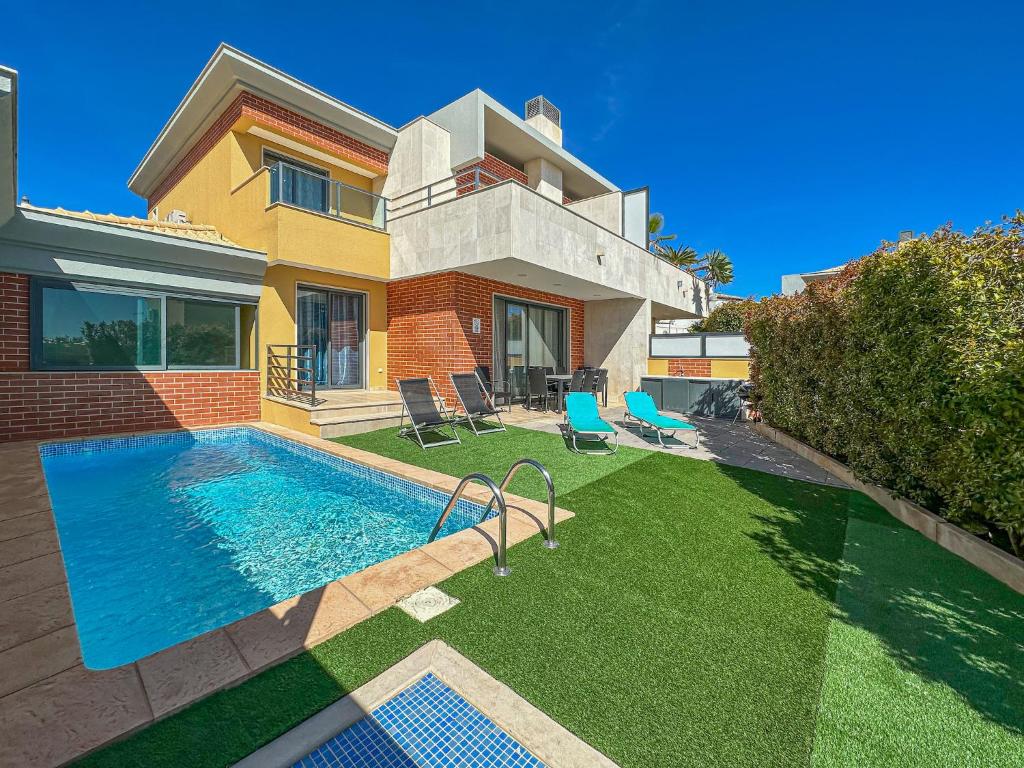 une maison avec une piscine dans la cour dans l'établissement V4, Villa Jardins Branqueira7 near Beach, Albufeira, à Albufeira