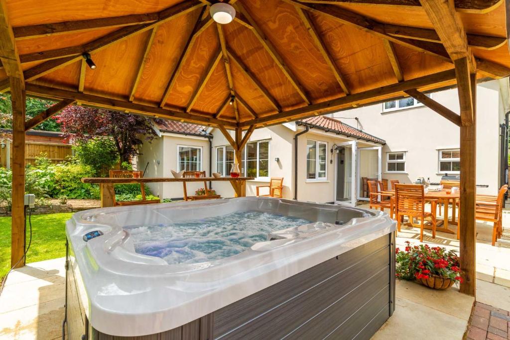 a hot tub in the backyard of a house at Woodside House in Costessey
