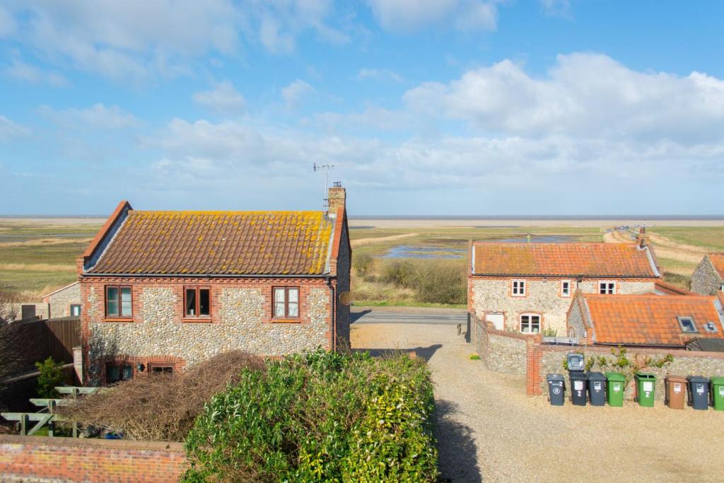 a group of houses with trash cans in front of them at Tystie Cottage in Salthouse
