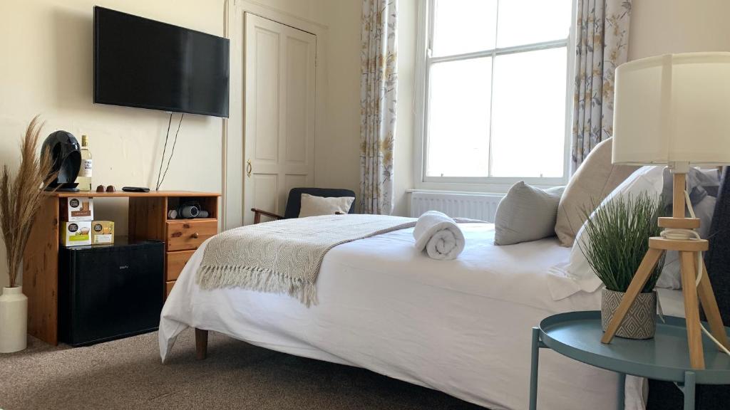 um quarto com uma cama grande e uma televisão na parede em Townhouse Plymouth em Plymouth