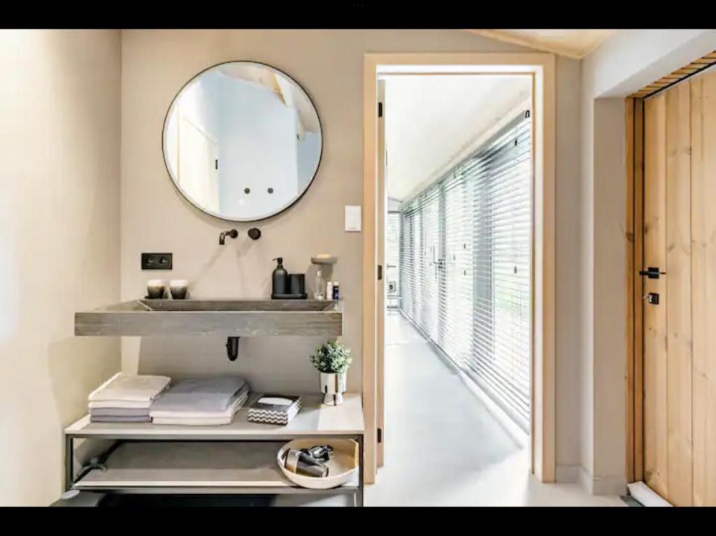 La salle de bains est pourvue d'un lavabo et d'un miroir mural. dans l'établissement Bulsomhuys, à Kampenhout