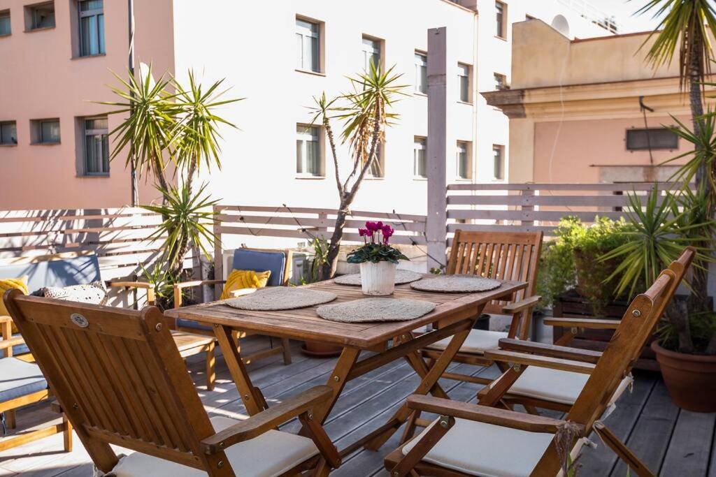 Prive terrace in El Born, near the beach في برشلونة: طاولة وكراسي خشبية على الفناء