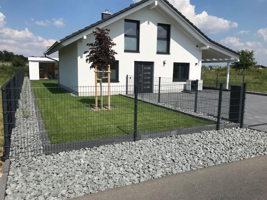 una cerca frente a una casa blanca en Ferienhaus Oskar 100m Entfernung zum See/Strand, en Löbnitz