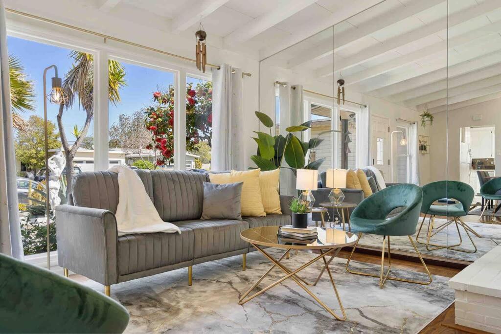 uma sala de estar com um sofá, uma mesa e cadeiras em Mid Century Garden View Home Parking em San Mateo