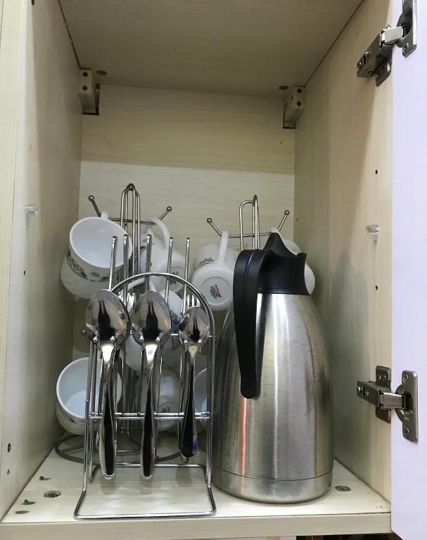a kitchen shelf with utensils and a tea kettle at Maliaways Comfy Airbnb-Jkia in Nairobi