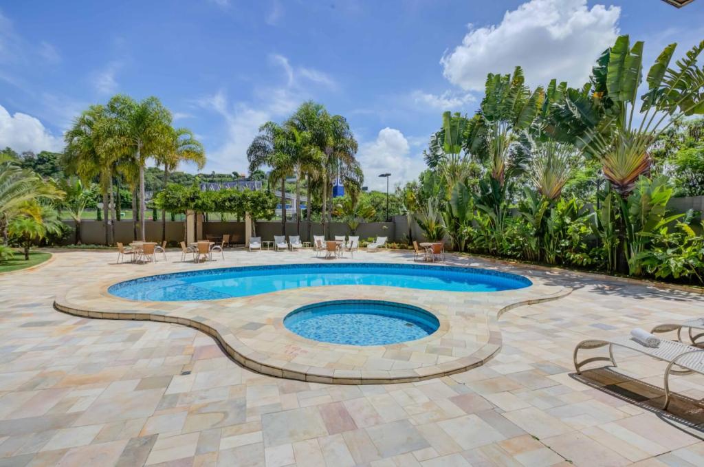 - une piscine avec une terrasse et des arbres dans l'établissement Quality Hotel Jundiaí, à Jundiaí