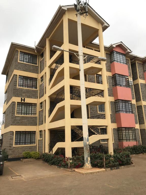 a large apartment building with a pole in front of it at Maliaways Comfy Airbnb-Jkia in Nairobi