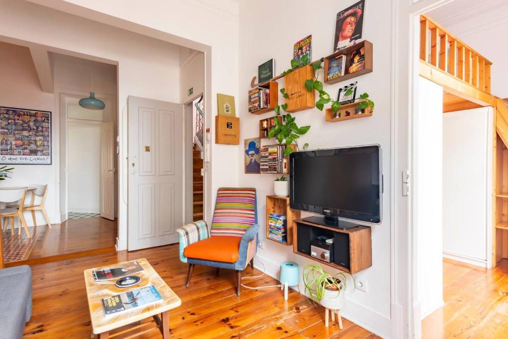 een woonkamer met een flatscreen-tv aan de muur bij Say What Lisbon? — Street Art / Family Apartment in Lissabon