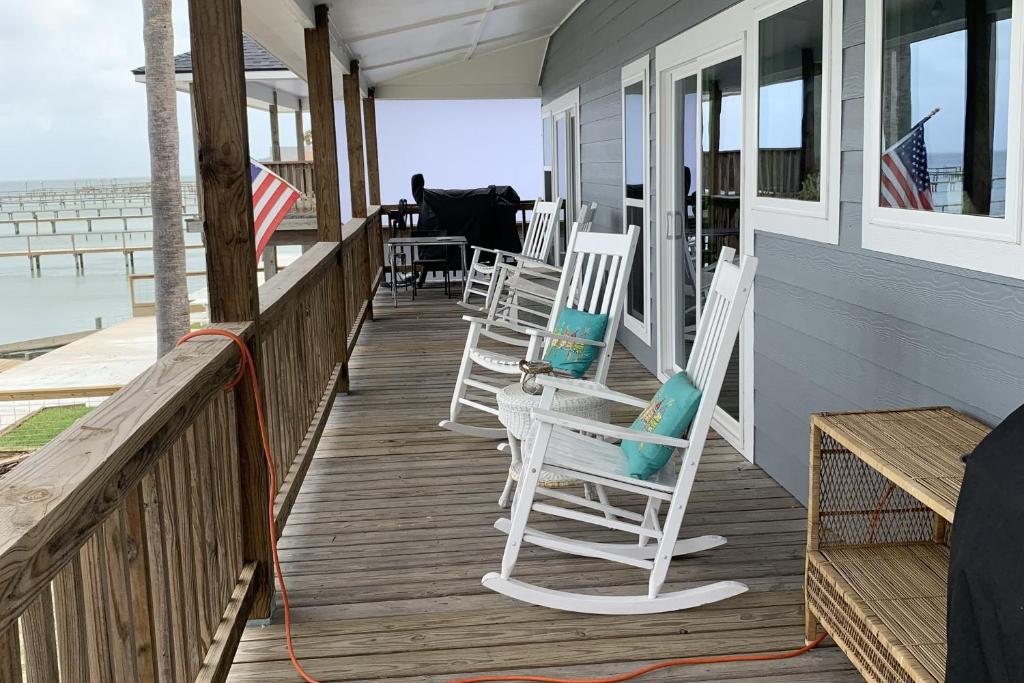 a porch with white rocking chairs on a house at The Ridge in Rockport