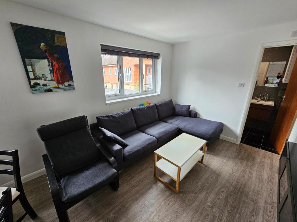 ein Wohnzimmer mit einem Sofa und einem Tisch in der Unterkunft Entire 2 bed Flat Ela Rosa fully serviced in Elmers End