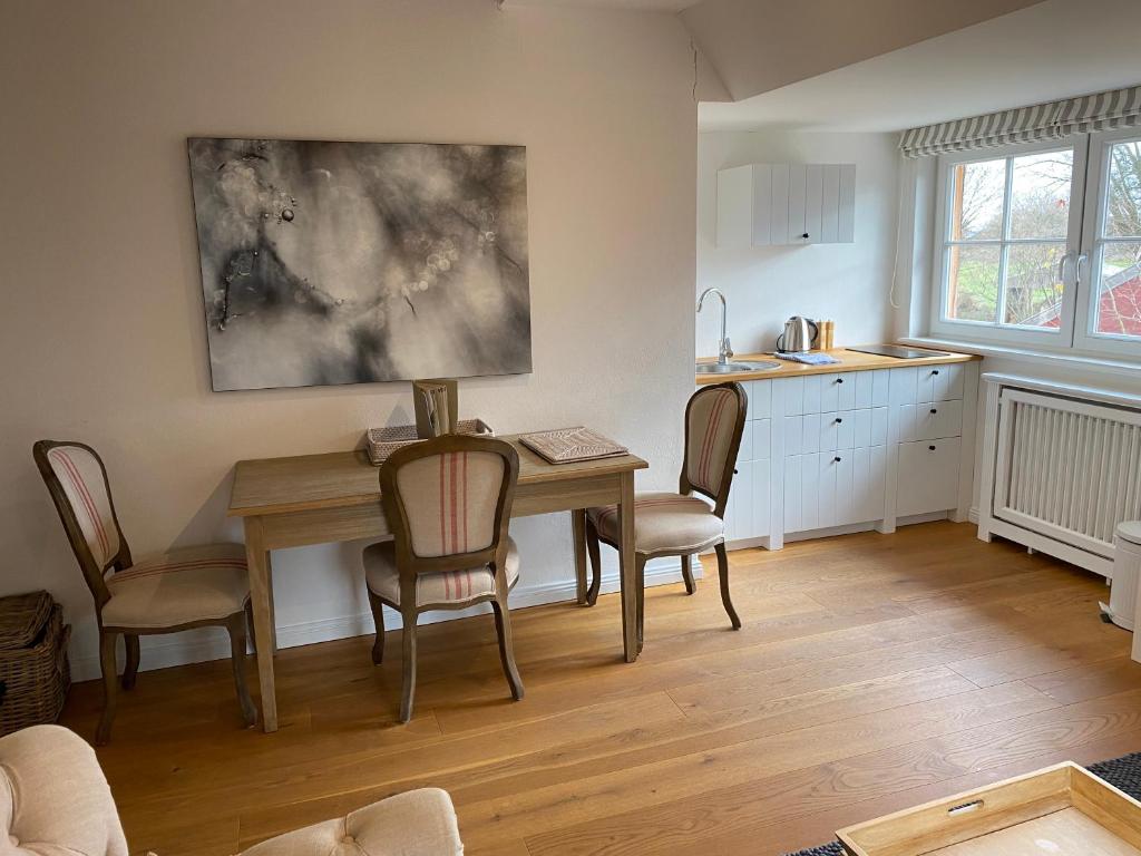 una cucina e una sala da pranzo con tavolo e sedie di HofGut Bockelkathen Apartment 3 a Lüdersburg