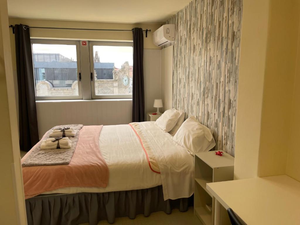 - une petite chambre avec un lit et une fenêtre dans l'établissement Liber Guest House, à Braga