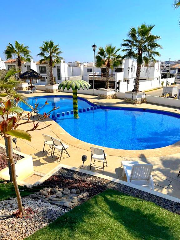 a large swimming pool with chairs and palm trees at Excelente Casa en Zona de Cerritos en Frente a Alberca - Azul Pacífico I in Mazatlán