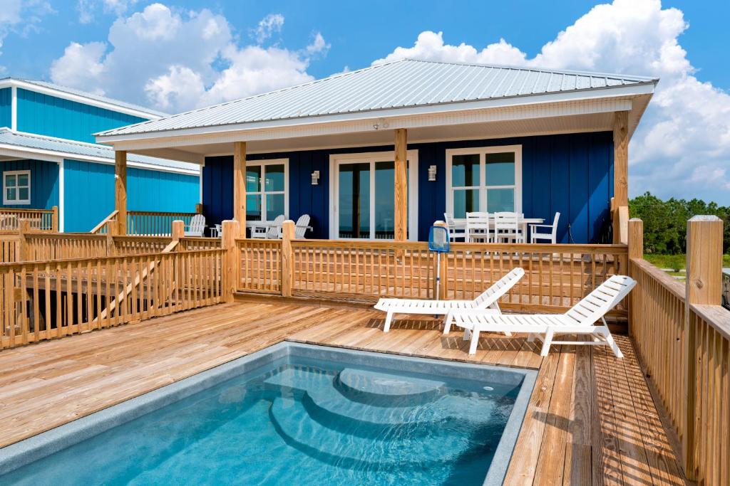 a house with a deck with a swimming pool and a house at Sunny & 75 in Dauphin Island