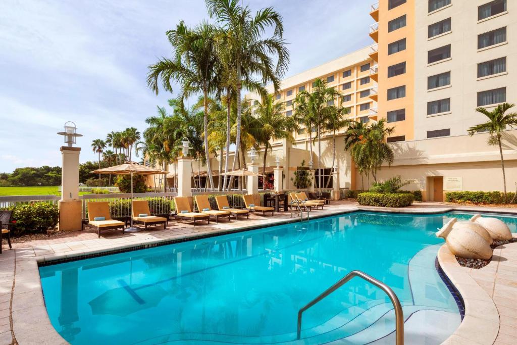 uma piscina num hotel com cadeiras e um edifício em Renaissance Fort Lauderdale West Hotel em Plantation