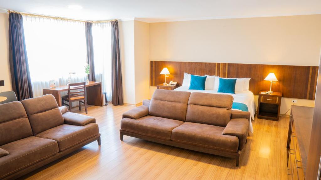 pokój hotelowy z łóżkiem i kanapą w obiekcie Fenix Hotel w mieście Quito