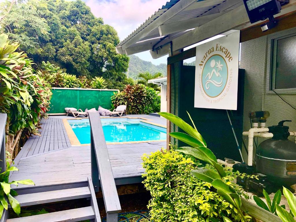 a swimming pool on a wooden deck next to a house at Avarua Escape, Rarotonga in Avarua