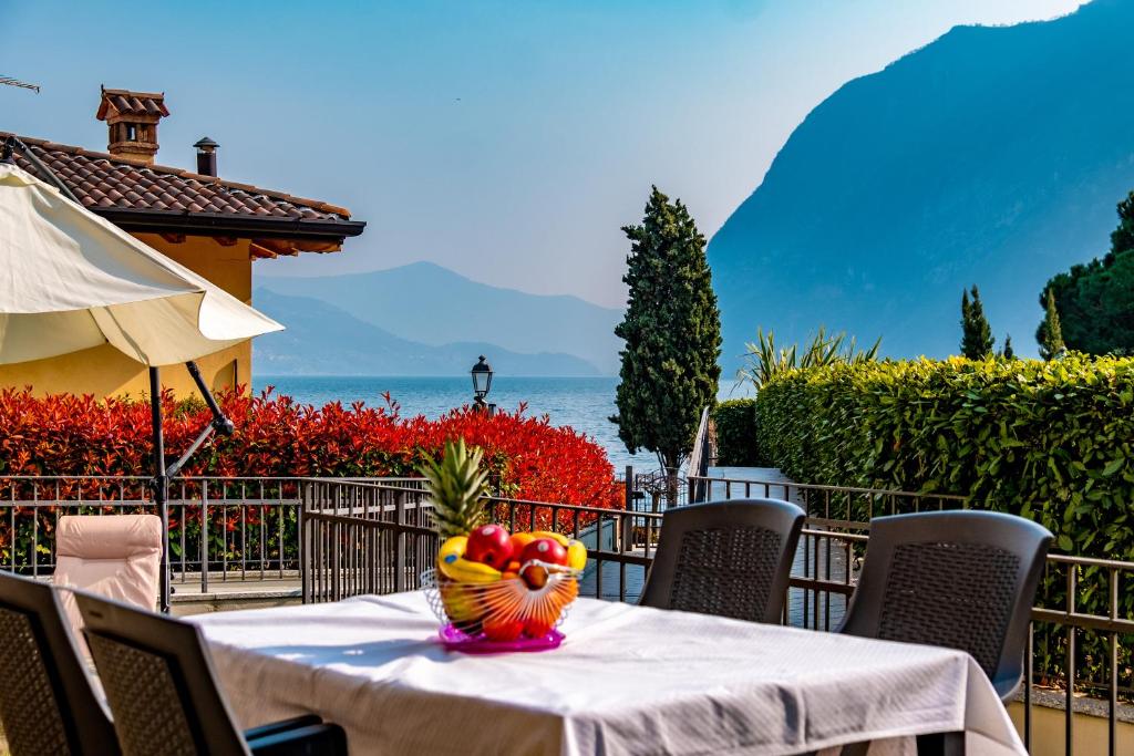 a table with a bowl of fruit on top of it at Happy Guest Apartments - Lake & Relax in Riva di Solto