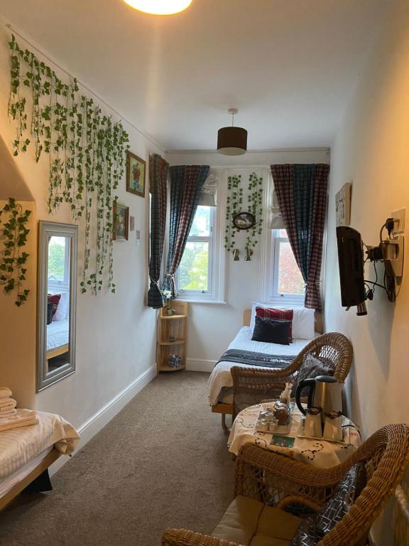 a bedroom with a bed and a couch and a table at The Palms Guest house in Torquay