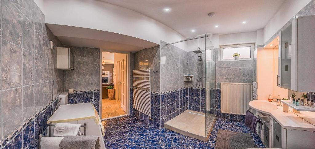 łazienka z prysznicem i umywalką w obiekcie Riverside Apartman**** Miskolc w Miszkolcu