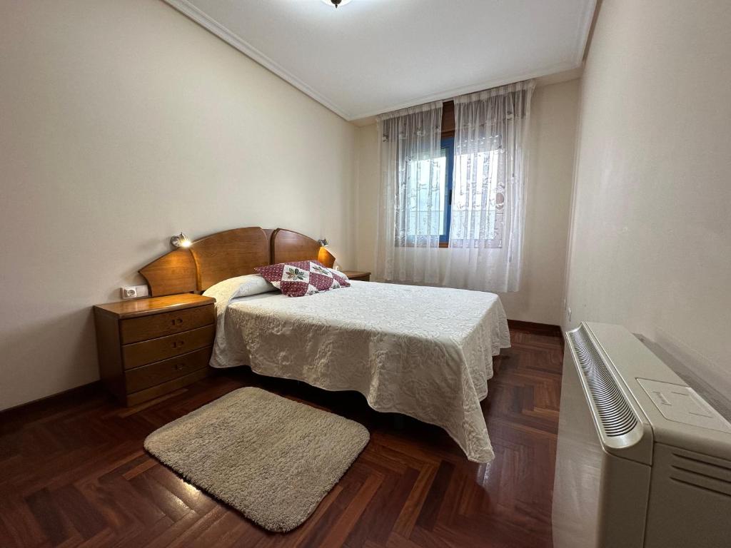 mała sypialnia z łóżkiem i oknem w obiekcie Apartamento Salgueirón w mieście Cangas de Morrazo