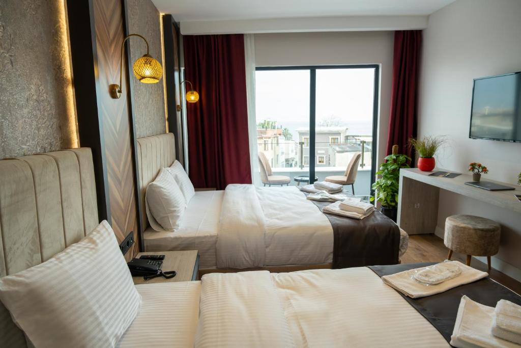 a hotel room with two beds and a balcony at Linda Port Hotel in Istanbul