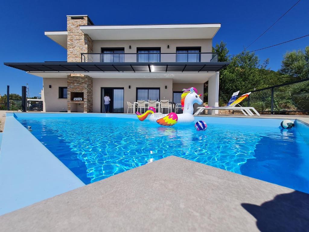 une maison avec une piscine devant une maison dans l'établissement Villa Mekasteni, à Cirendinu