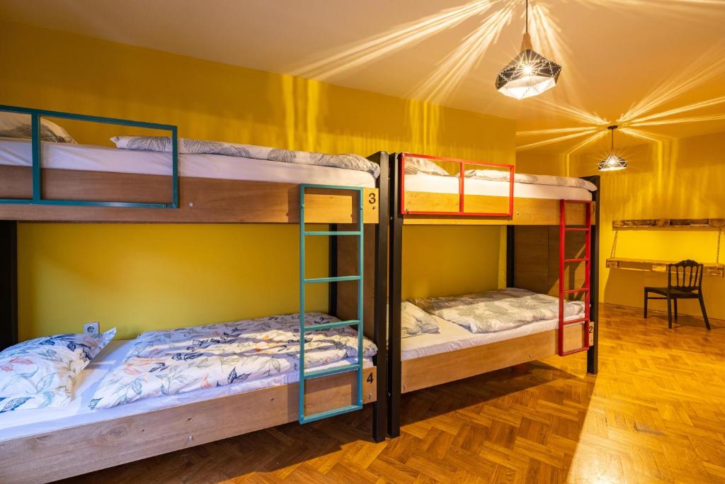 two bunk beds in a room with yellow walls at Hostel Prishtina Backpackers in Pristina