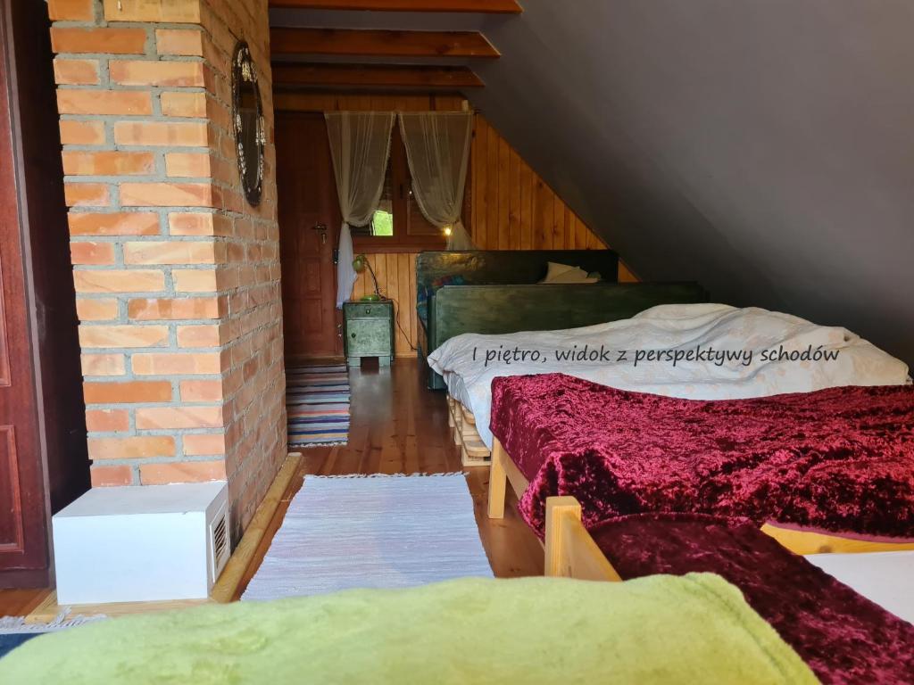 um quarto com três camas e uma parede de tijolos em Domek letniskowy w Szkotowie em Szkotowo