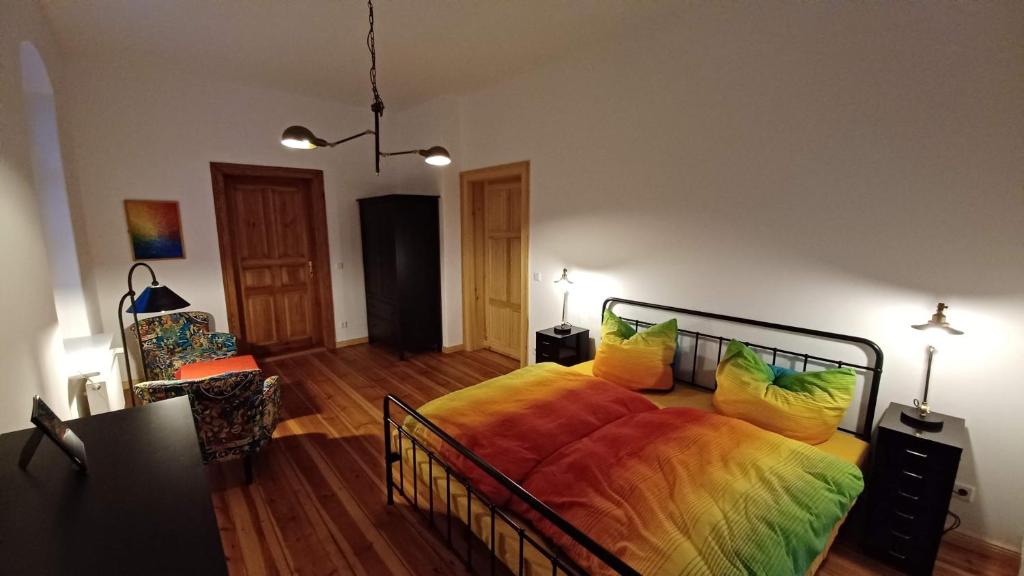 a bedroom with a large bed with colorful pillows at "Parkwohnung" im Kunstgut Krahne in Krahne