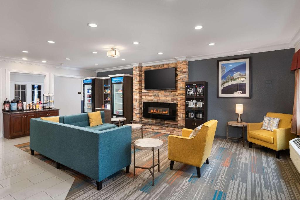 a living room with a couch and chairs and a fireplace at MainStay Suites Joliet I-55 in Joliet