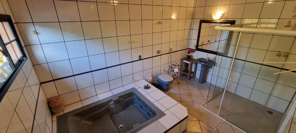 y baño con bañera y aseo. en Pousada SÃO JERONIMO CHAPADA en Chapada dos Guimarães