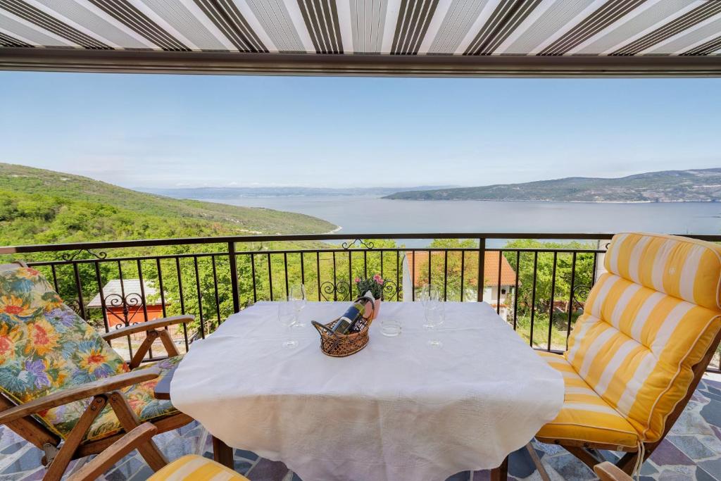 a table and chairs on a balcony with a view of the water at Holiday Home Elisa in Zagorje