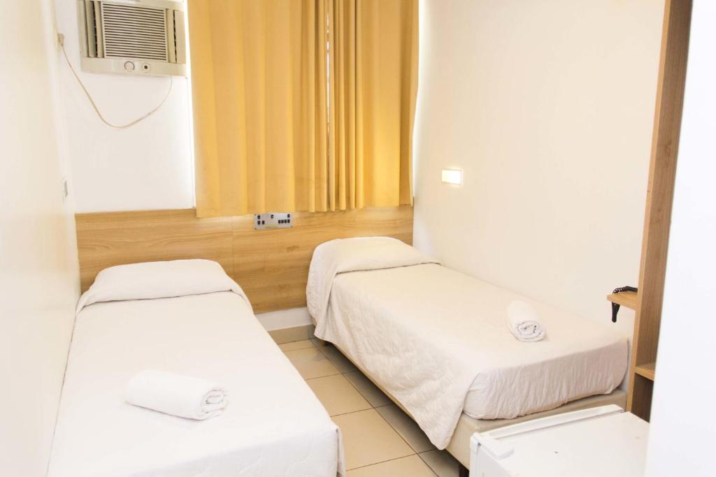 ein Krankenhauszimmer mit 2 Betten und einem TV in der Unterkunft Minuano Hotel Home próximo ao aeroporto in Porto Alegre