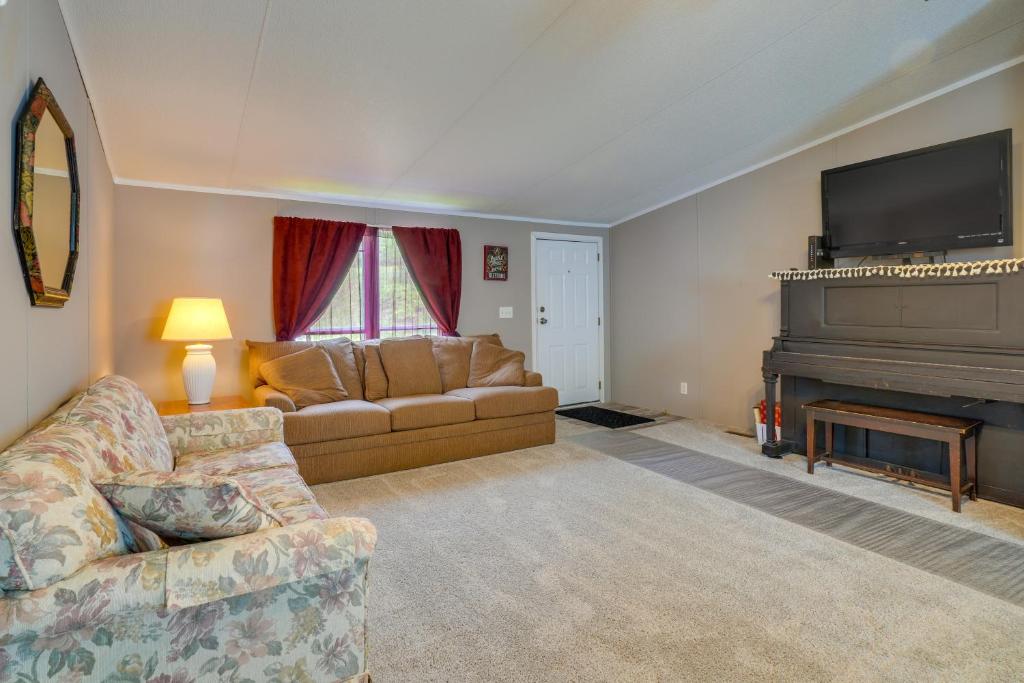 een woonkamer met een bank en een piano bij Tennessee Vacation Rental about 2 Mi to Windrock Park! in Oak Ridge