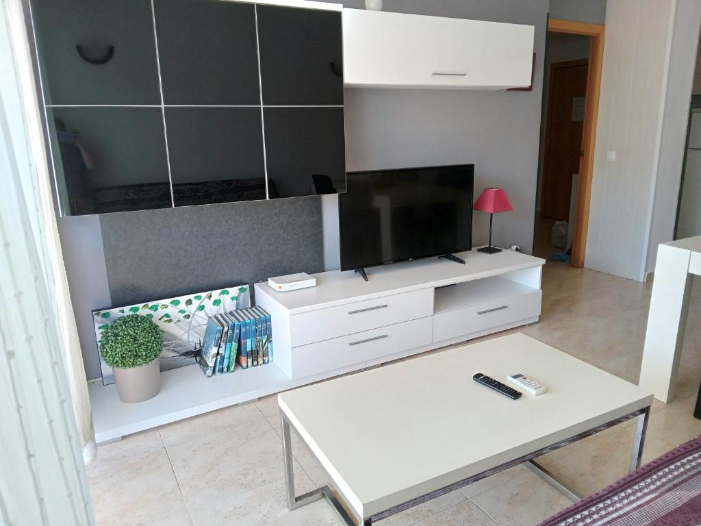 a living room with a tv and a white table at VANCOUVER en SALOU in Salou