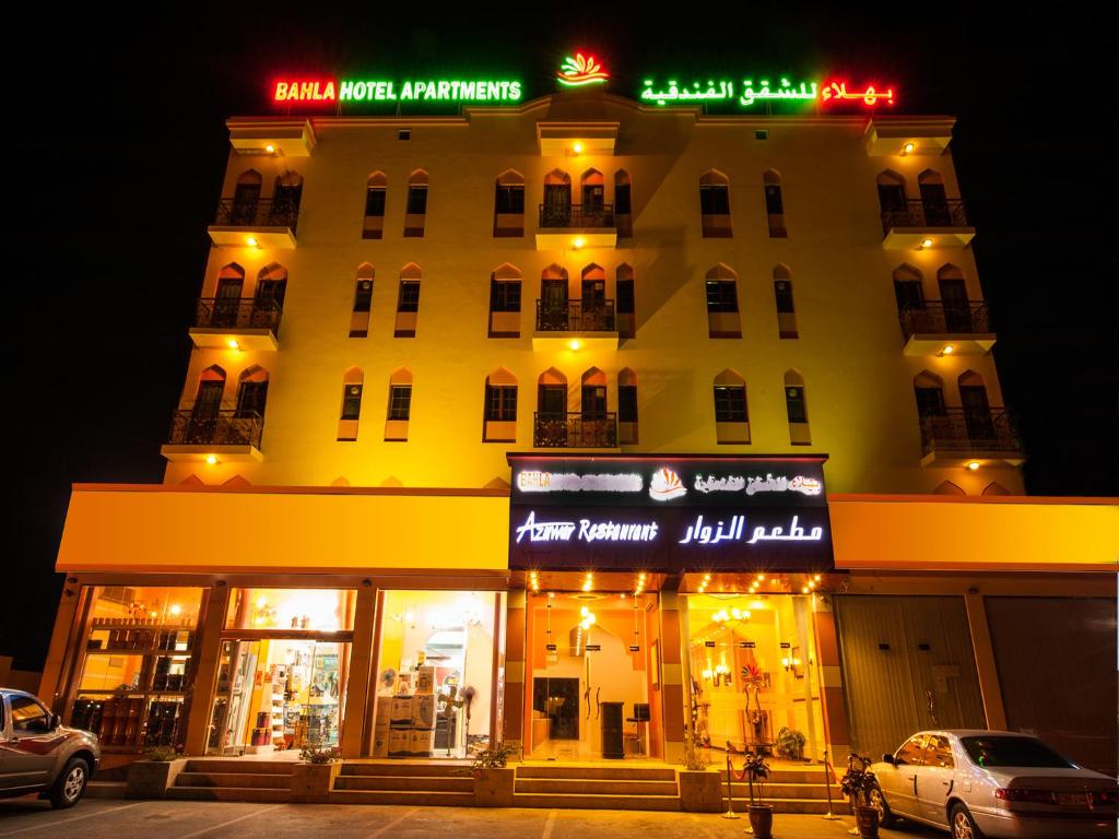 a large white building with a sign on it at Bahla Hotel Apartments in Bahlāʼ