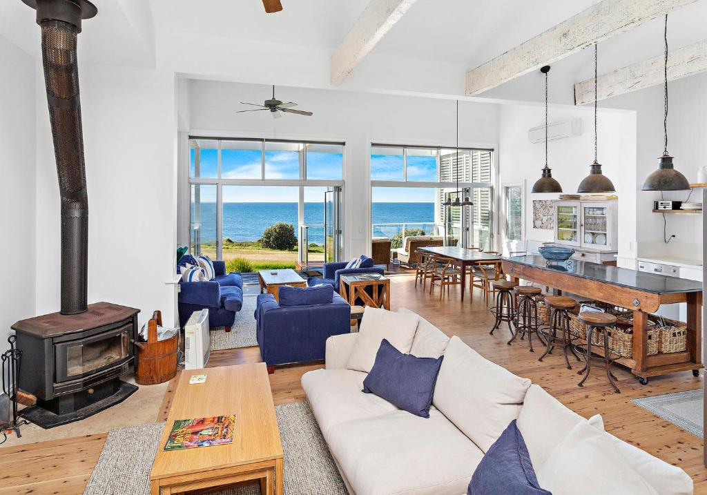 un soggiorno con divano, tavolo e camino di Hamptons Escape a Gerroa