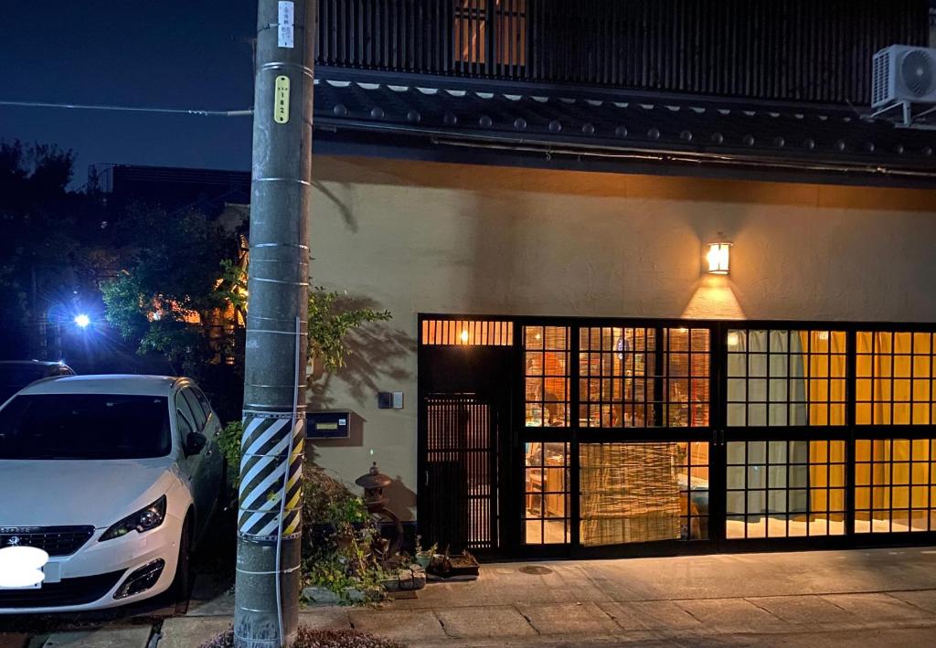un coche aparcado delante de un edificio por la noche en 小京都の宿 へうたん, en Nishio
