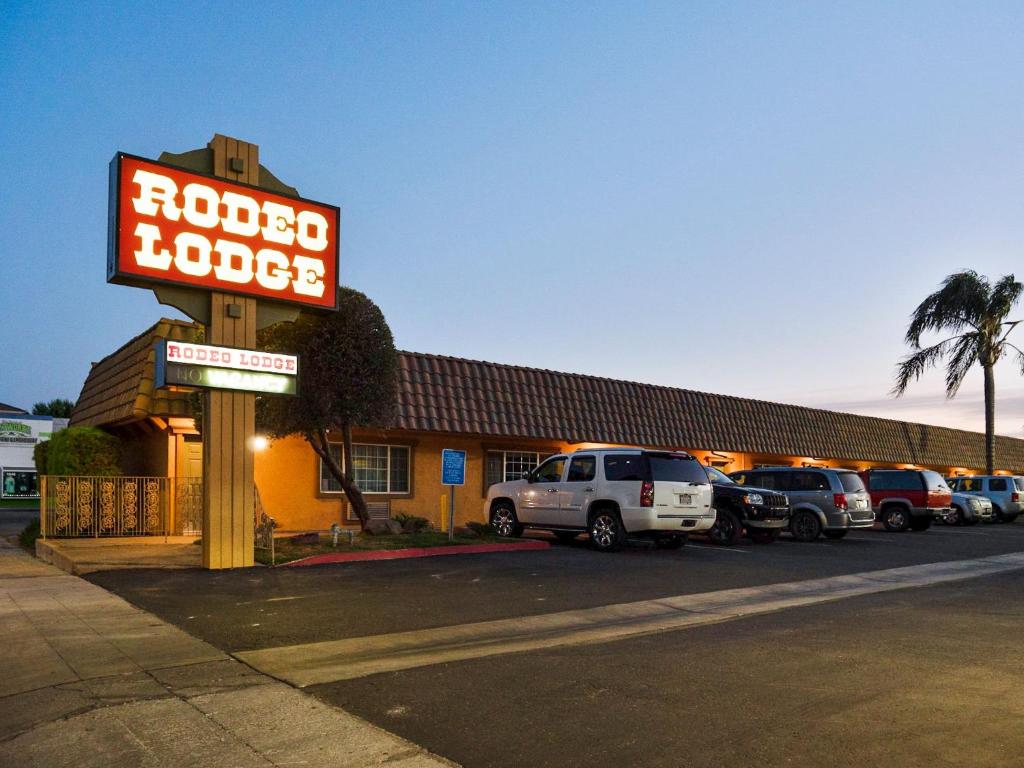 a rocca motel sign in front of a parking lot at Rodeo Lodge in Clovis