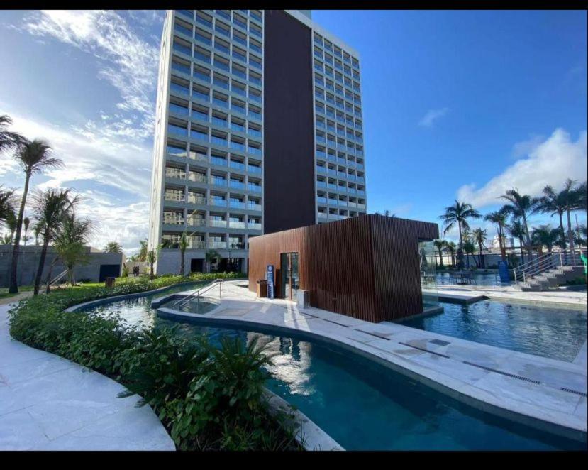 a large building with a swimming pool in front of a building at Salinas Premium Resort in Salinópolis