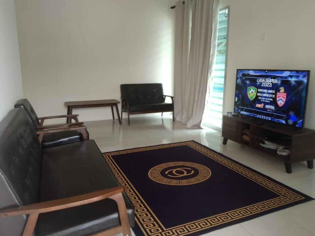 a living room with a couch and a tv at Homestay Delisha Tapah-Pool in Tapah