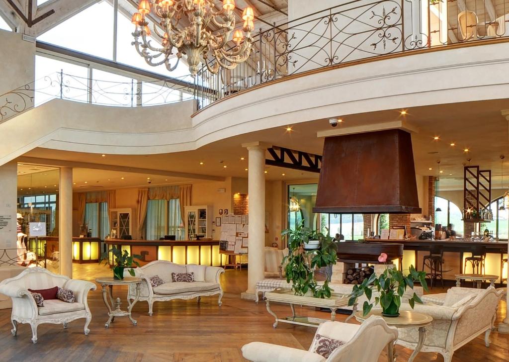 duży hol z białymi meblami i żyrandolem w obiekcie Garda Residence San Vigilio Golf w mieście Pozzolengo