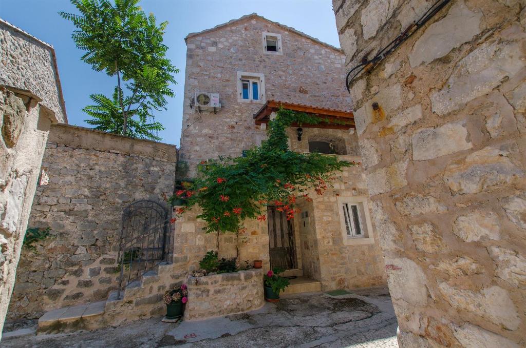 un antiguo edificio de piedra con una torre en House Stone house in center en Jelsa