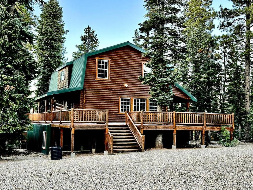 a log cabin with a staircase and a house at Backwoods Bonanza - Big Cabin With Hot Tub! in Duck Creek Village